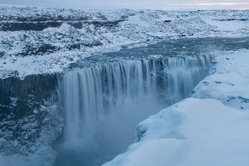 Long exposure photo of Dettifoss waterfall with snow on the foreground