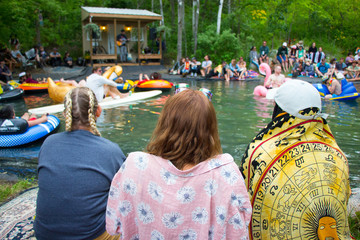 Young People by Pond at Music Festival in Summer