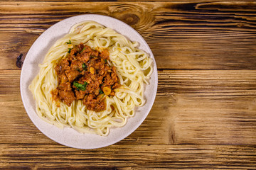 Pasta with bolognese sauce in a ceramic plate. Top view