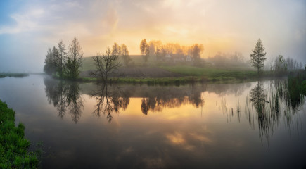 Naklejka na ściany i meble fog in the river valley. picturesque spring morning. beautiful foggy sunrise in a foggy meadow