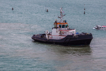 Tugboat working in the port of Venice, Italy. Concept: maritime transport, commerce, shipbuilding industry, maritime trade