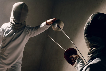 Fencer woman with fencing sword. Fencers duel concept.