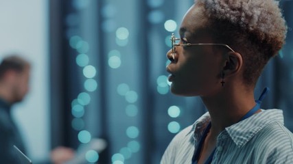 Professional female engineer in database learning technology inspecting server supercomputer at cyberspace coworking in team inside data center. Close-up. Beautiful smart people. - Powered by Adobe