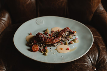 plato redondo con comida, pulpo rojo con flores y salsa