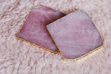 Rose quartz coasters on the pink background. 