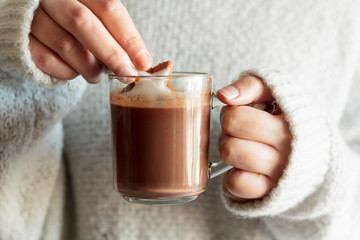Woman hands dipping cookie in hot chocolate