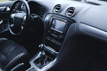 Modern car interior. Steering wheel, gearshift lever, multimedia system, driver's seat and...