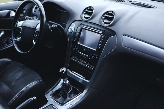 Modern car interior. Steering wheel, gearshift lever, multimedia system, driver's seat and dashboard.