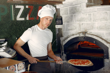Chef prepare the pizzaa. Man in a white uniform