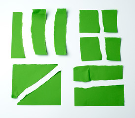 various blank pieces of green paper on white background,