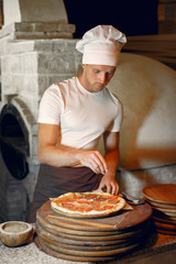 Chef prepare the pizzaa. Man in a white uniform