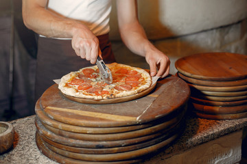 Chef prepare the pizzaa. Man in a white uniform