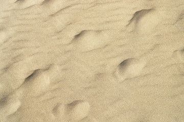 The texture of the beach sand of gray color.