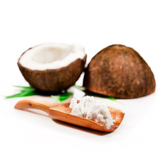 Fresh cracked coconut and coconut meat in a wooden spoon isolated on white background.