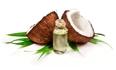 Coconut with green palm leaves and melted coconut oil isolated on white background.