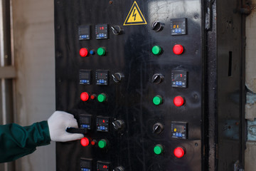 Control panel with red and green buttons in the production hall at the furniture factory