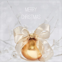 Square composition, text "Merry Christmas". Xmas arrangement in golden and white on abstract winter background. Gilded gold color bauble with gorgeous golden bow with white paper flowers.