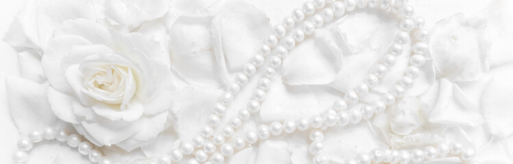 Beautiful white rose and pearl necklace on a background of petals. Ideal for greeting cards for...
