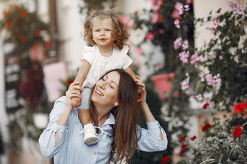 Mother with daughter. Family in a city. Woman in a blue dress