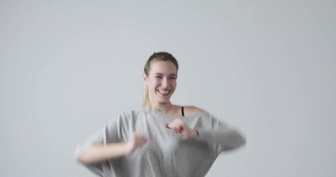 Elated young woman celebrating victory over white background