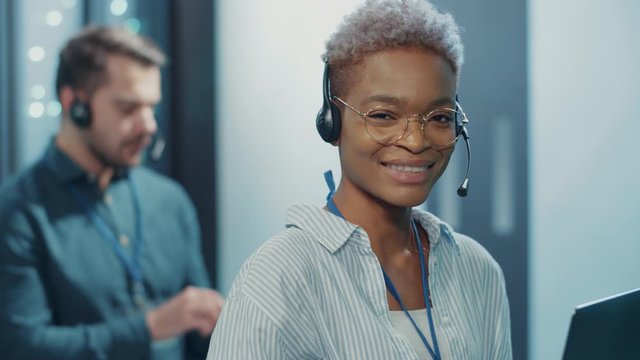 Administrator woman using laptop technology working on servers at database. Portrait happy black female tech support enjoying satisfying job in modern data center.
