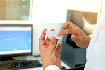 Hand holding sheet PMMA acrylic plate to apply sunscreen for measurement of radiation protection of...
