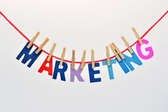 la palabra marketing hecha con letras de madera, pillada a una cuerda con pinzas de la ropa