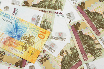 A yellow, ten Swiss franc note from Switzerland close up in macro with Russian one hundred ruble bills