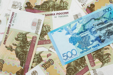 A blue five hundred tenge note from Kazakhstanwith Russian one hundred ruble bills close up in macro