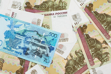 A blue five hundred tenge note from Kazakhstanwith Russian one hundred ruble bills close up in macro
