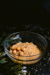 Chickpea hummus with sesame in glass bowl on wooden table. Vegan food