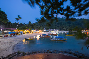 Fototapeta na wymiar Pulau Perhentian, Terengganu - August 14th, 2018 : Beautiful view of small Perhentian Island with multiple boats during blue hour. Image contains noise and soft focus