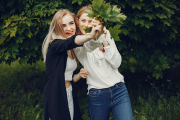 Obraz premium Pretty girls in a summer park. Friends walking in a city. Ladies with blonde hair