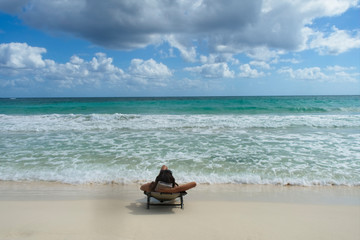 a young woman relaxes on the shore of a Caribbean beach