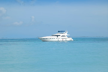 Fototapeta na wymiar Super luxury motor yacht stopped in front of a white Caribbean beach. White beach and crystal clear turquoise sea. Isla Mujeres Mexico.