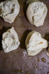 Baking domestic rolls with cheese. Putting cheese on dough for rolls