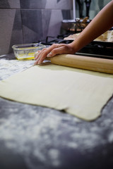 Baking domestic rolls with cheese. Putting cheese on dough for rolls