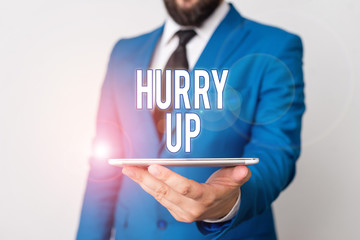 Conceptual hand writing showing Hurry Up. Concept meaning asking someone to do a job very fast Quickly Lets go Encourage Businessman in blue suite with a tie holds lap top in hands