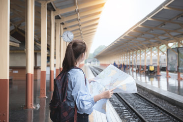Obraz premium Beatyful woman with maps at train station. travel concept.