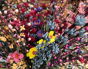 Background of bright colorful artificial flowers. Close up.Selected Focus.