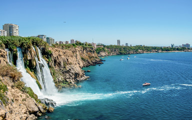 Fototapeta premium Wodospad Duden w Antalya Turcja widok z góry na górę z wybrzeża prom na tle błękitnego morza i miasta portowego - piękna plaża Antalya Turcja krajobraz podróży punkt orientacyjny