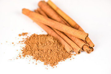 Cinnamon sticks and cinnamon powder herbs and spices on white background /
