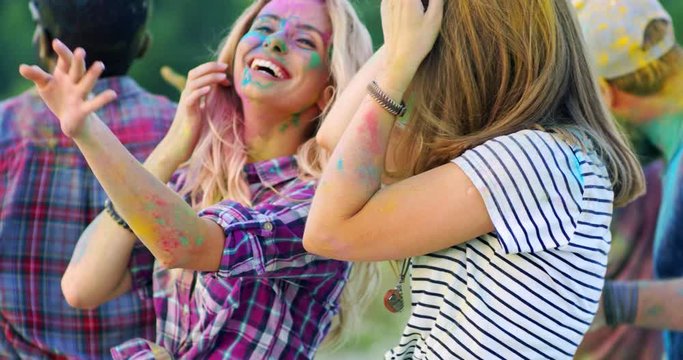 Holi religious festival outside in the field. Mixed-races young cheerful smiled people celebrating Indian holiday.