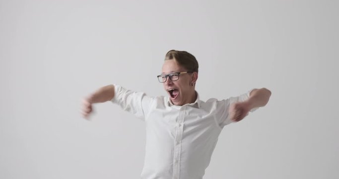 Crazy young man having fun dancing over white background
