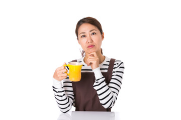 マグカップを持つエプロン姿の女性