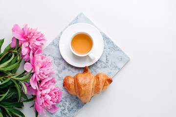 Breakfast for Valentines day with cup of tea, croissant, flowers on white table from above in flat lay style, seasonal springtime holiday background, blogger lifestyle