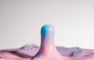 High resolution high megapixel image of a water drop splash with pink, red, blue, and baby blue,...
