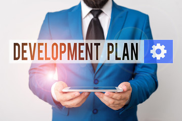 Text sign showing Development Plan. Business photo text the planning of the development of an area of land Businessman in blue suite with a tie holds lap top in hands
