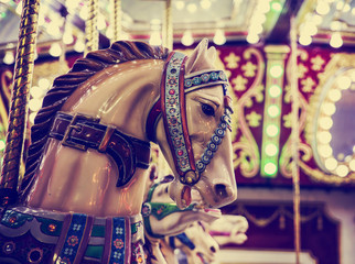 merry-go-round wooden horses toned with a retro vintage instagram filter app or action effect...