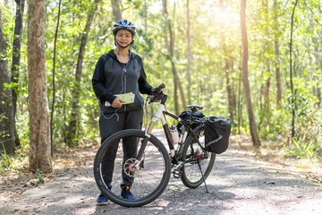 Obraz premium Senior asian woman riding bikes in park with hold map on trip